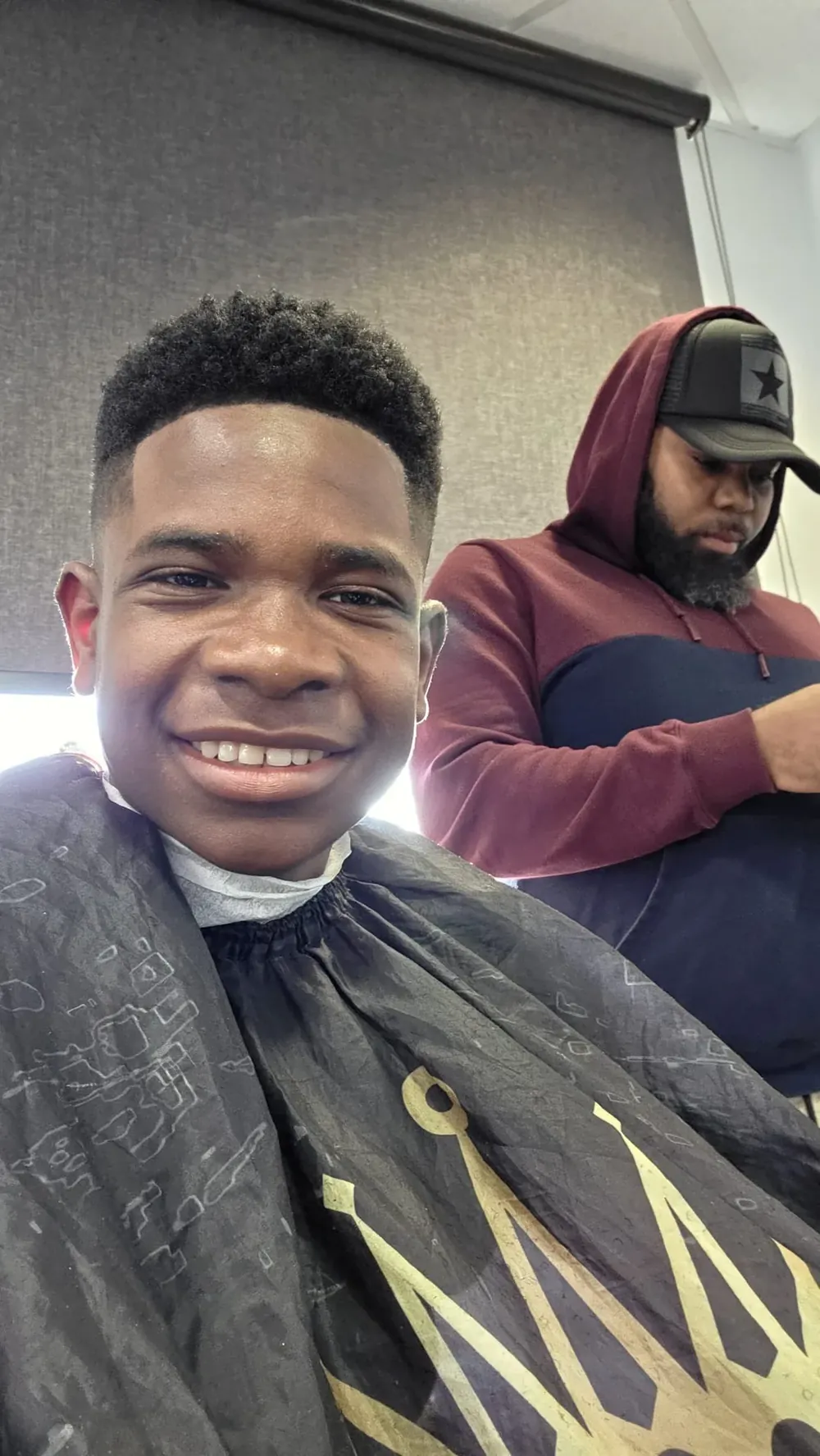 Client satisfait avec dégradé afro chez VIP Spot Barbershop